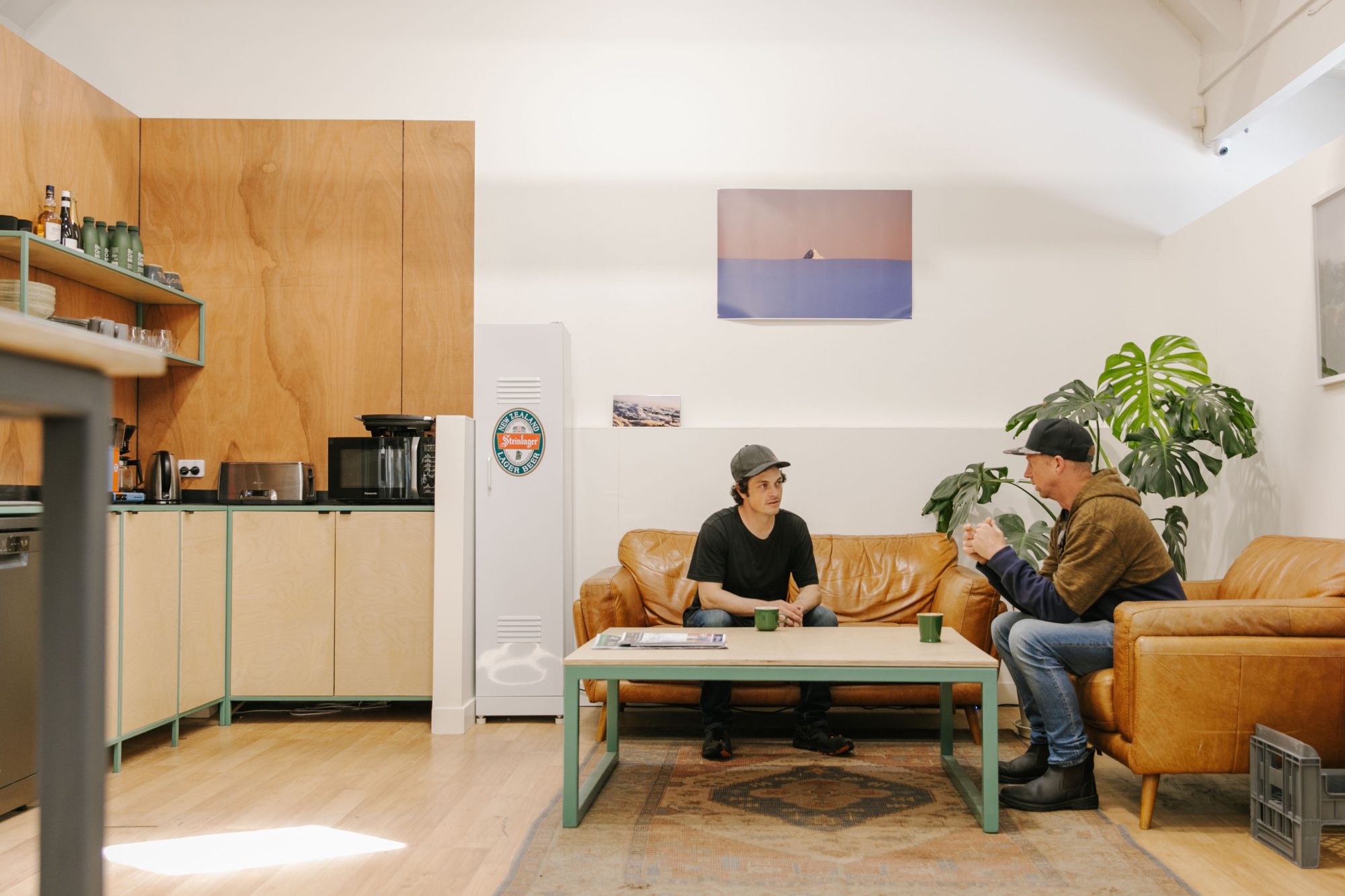 Two men having a conversation on a couch.