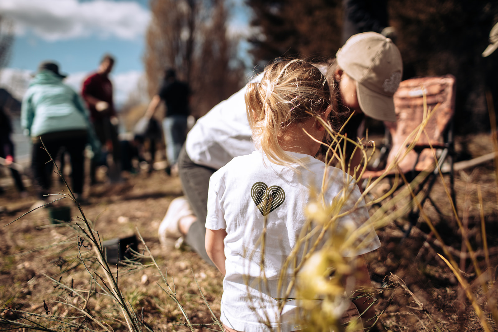 Mother and child planting a native seedling together