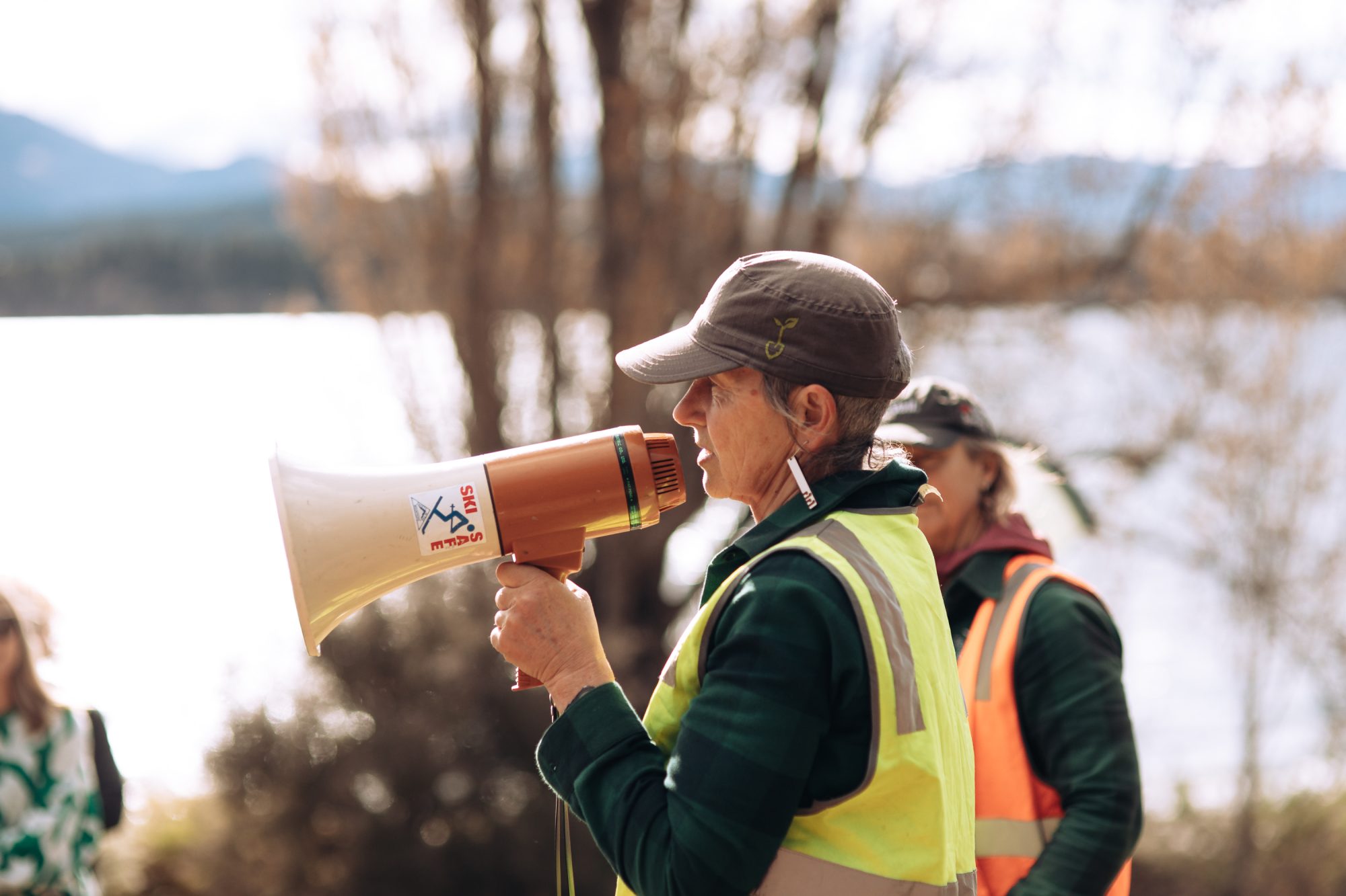 Woman speaks into a megaphone at planting event