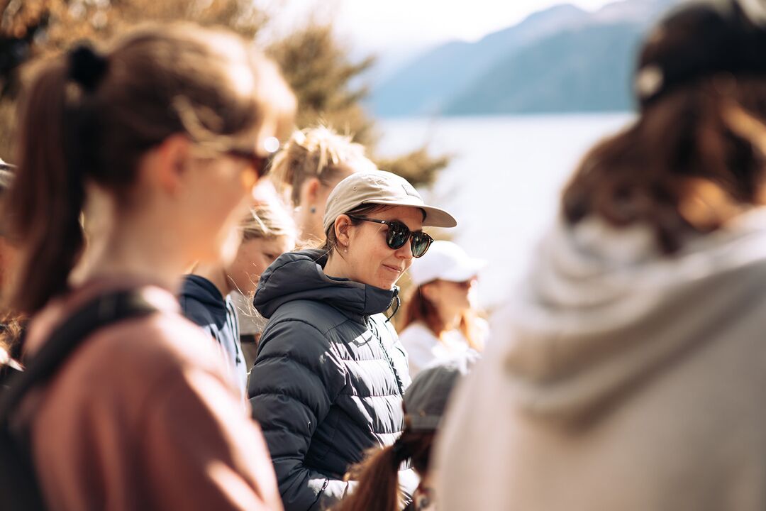 Volunteers sharing a laugh at Love Wanaka and Te Kākano Trust community event, with Rippon Winery's mountain views in background