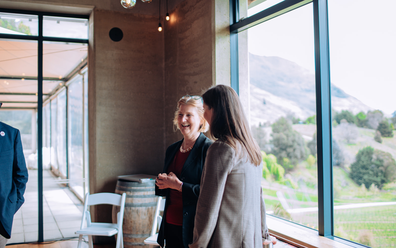 Two people converse at a conference overlooking a scenic landscape