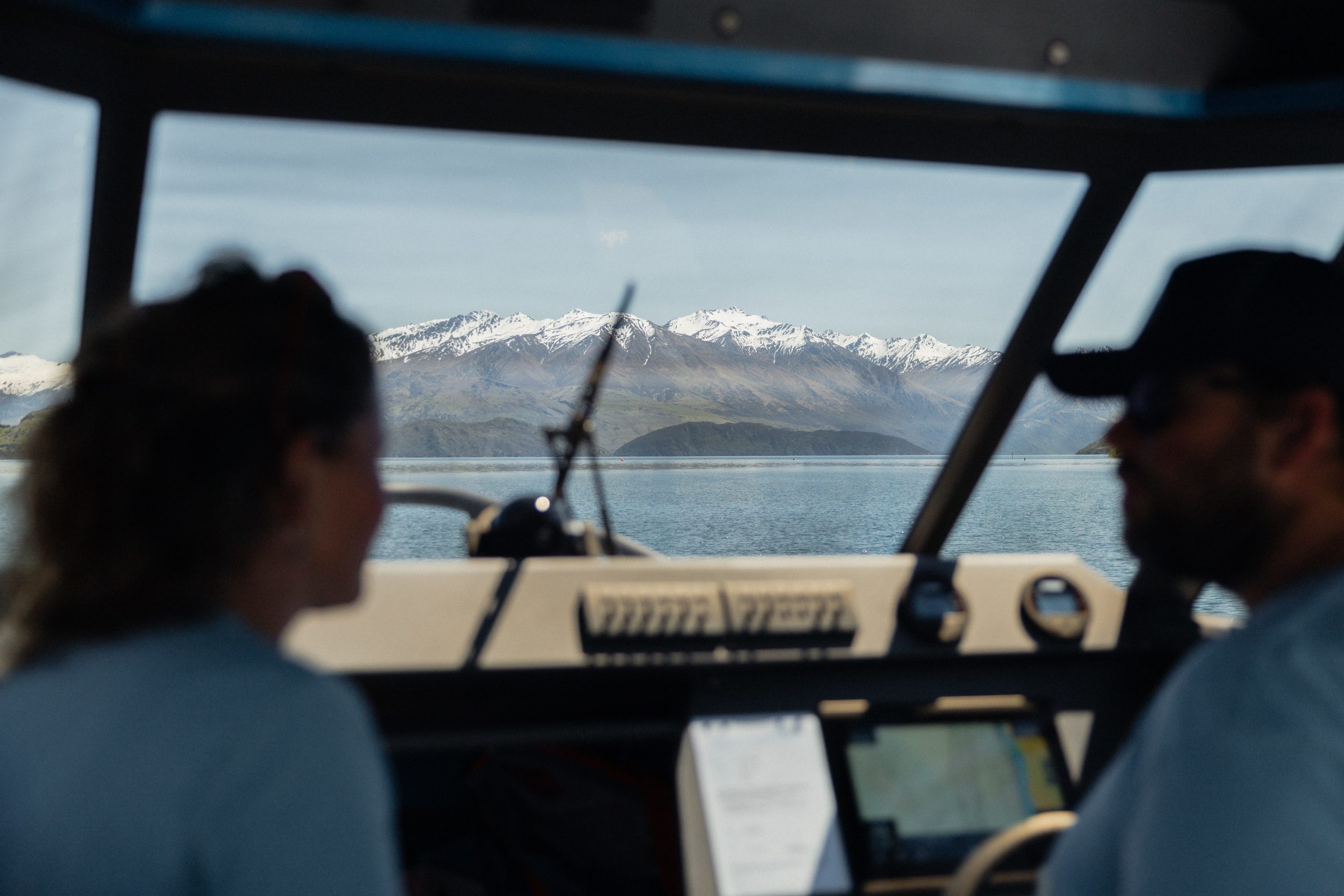View from cab of boat out to mountains and lake