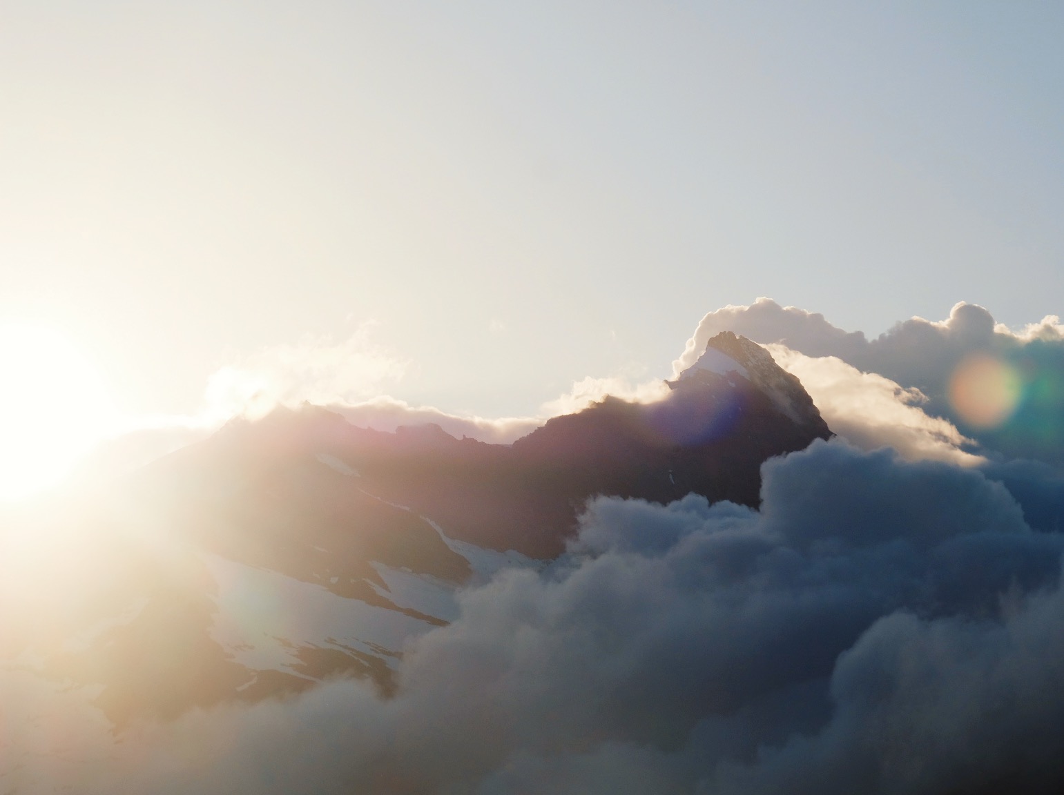 dramatic sunset over a ragged mountain range with clouds rolling in in Wānaka New Zealand