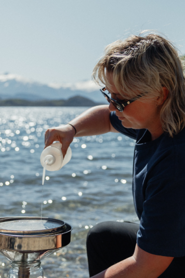 A WAI Wānaka Employee sampling water on the Wānaka Lake Front