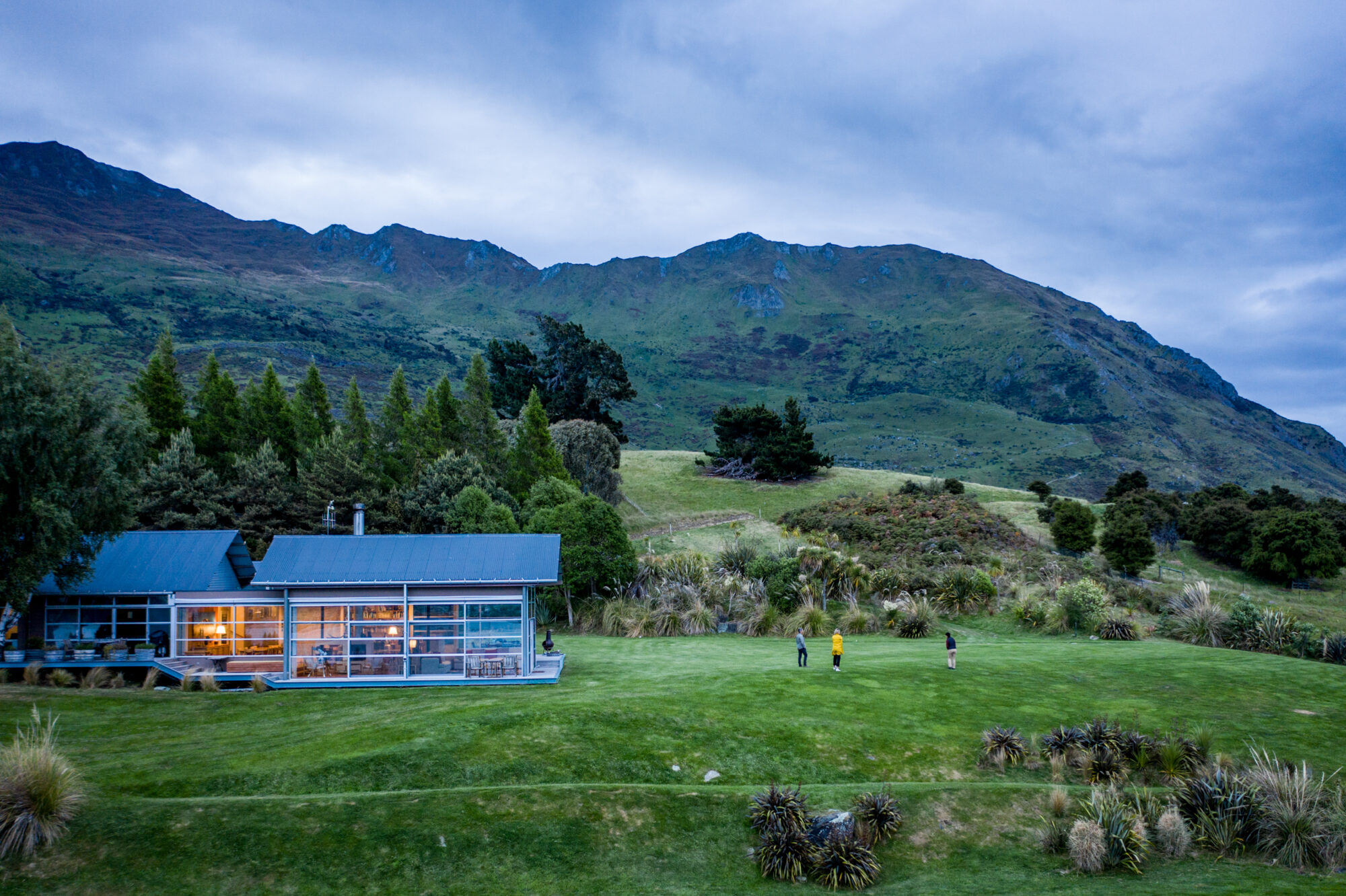 Drone view of Whare Kea Lodge, with people standing outside
