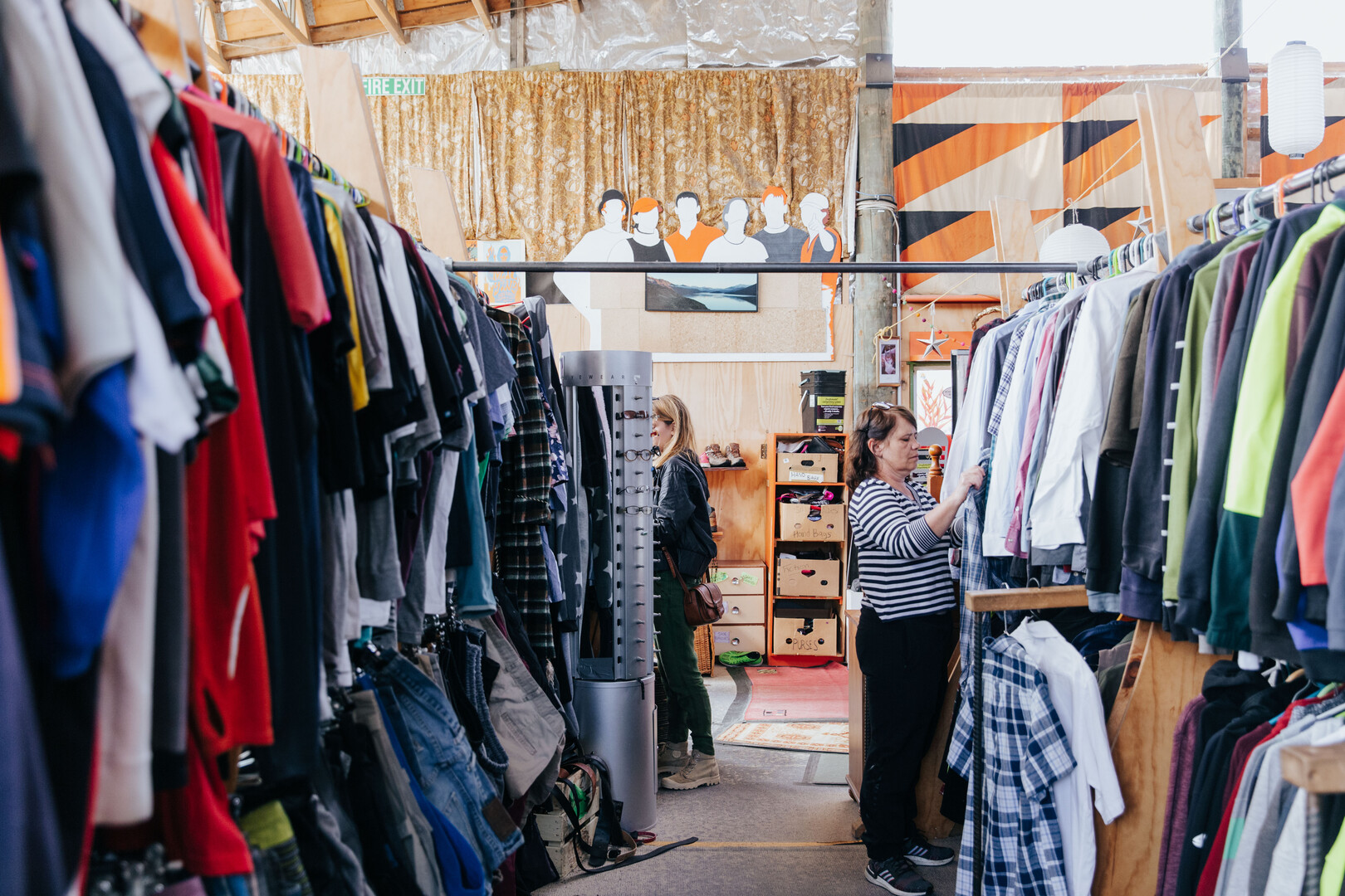 Shopper browses second-hand clothing at Wastebusters Wānaka